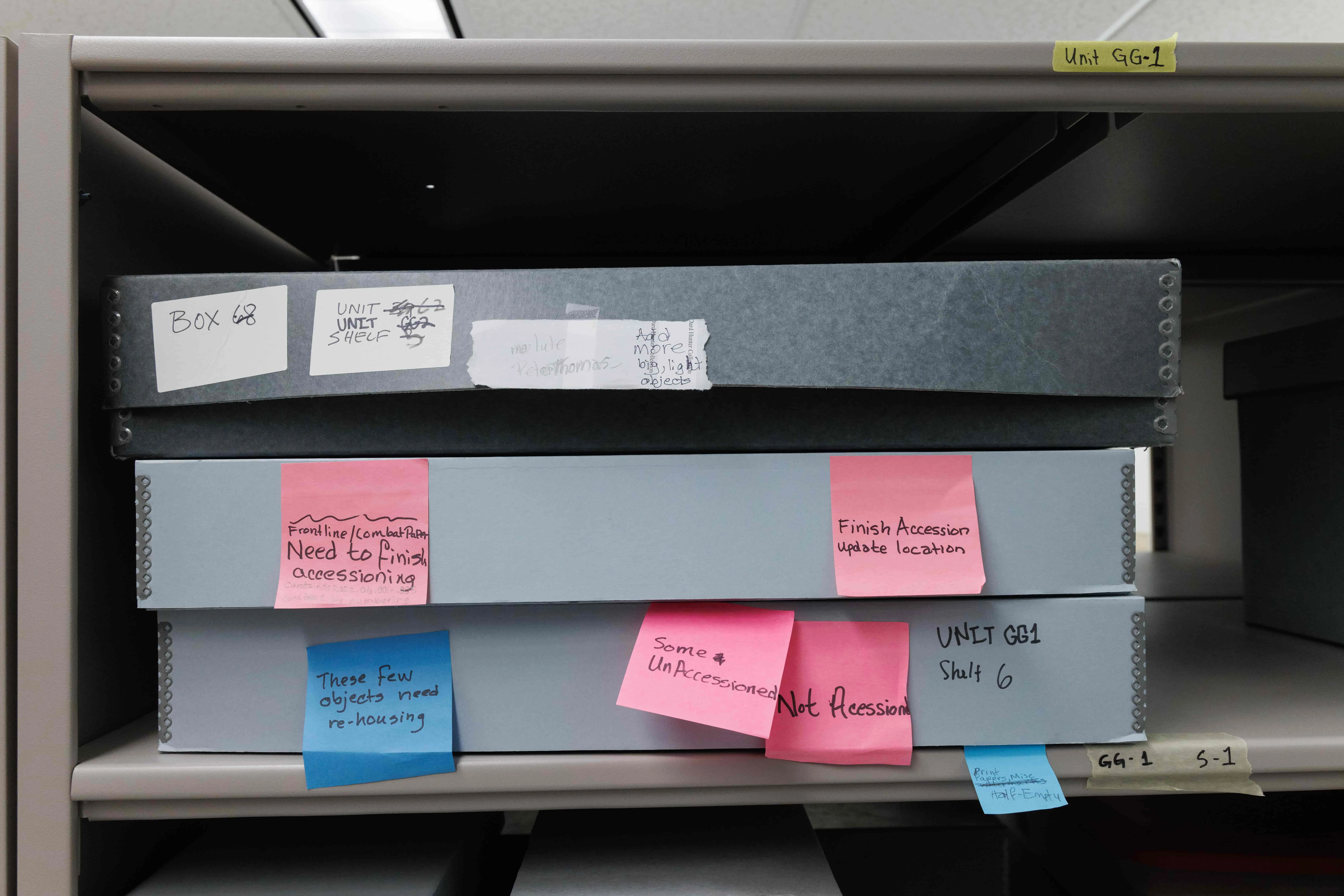 Archival boxes in Museum collection. Each box has multiple sticky notes labeled "Not Accessioned" and original location labels are crossed out.